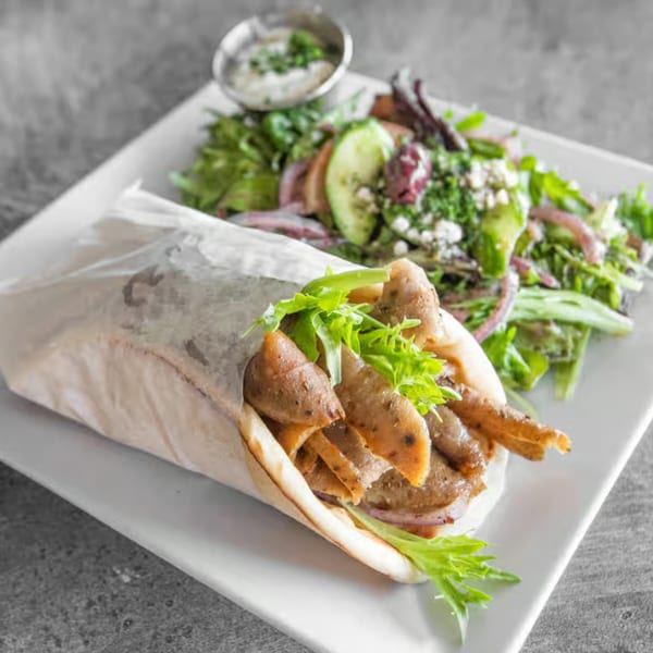 Athena Gyro's classic gyro with meat, lettuce, and onions, served with a side salad and tzatziki.